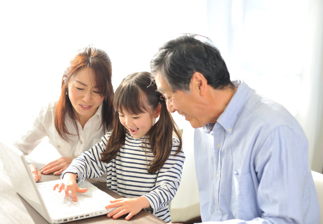 家族でパソコンを触っている