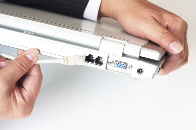 パソコンにLANケーブルを差し込んでいる